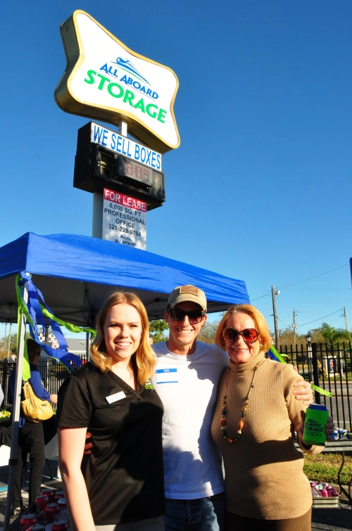 Emma, Spencer, & Lois posing in front of All Aboard Storage sign