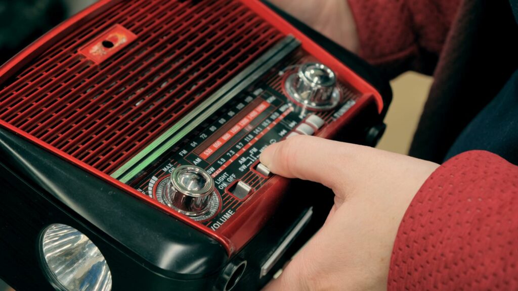 A closeup of a girl holding a battery-operated radio. 