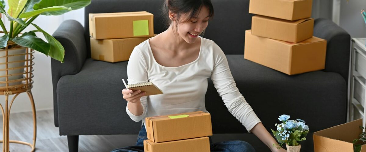 A young woman packs items into each box and labels them.