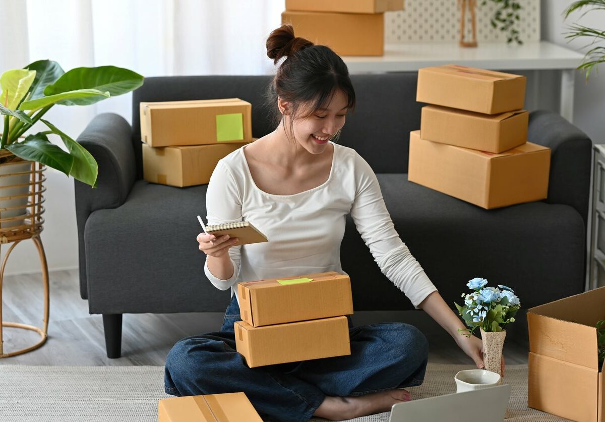 A young woman packs items into each box and labels them.