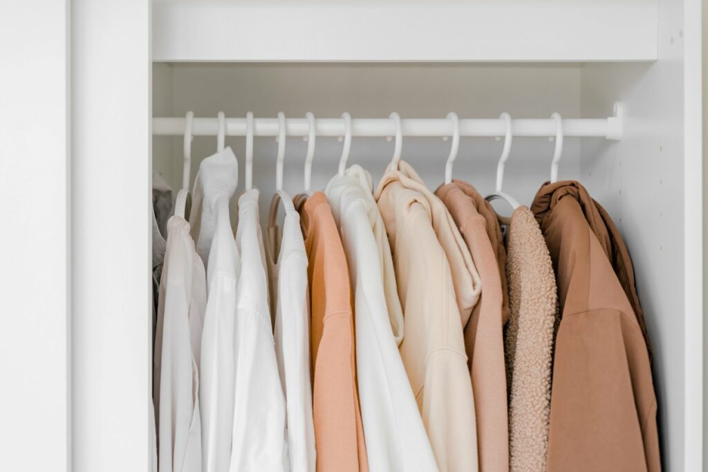  A close-up shot of fall and winter clothing inside a closet.