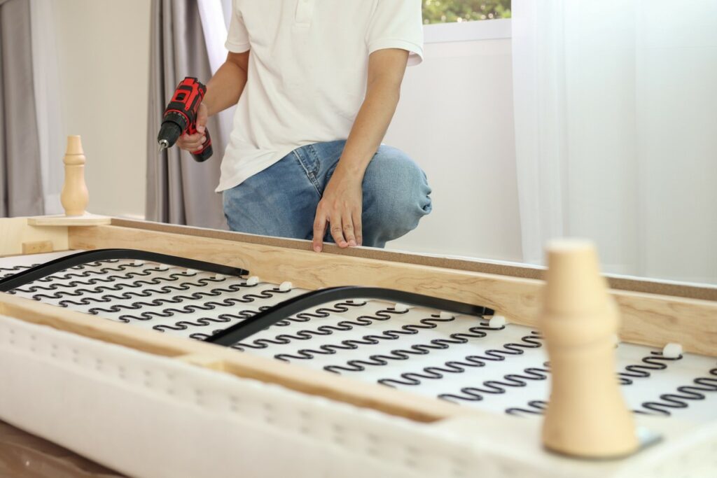 A young man disassembling furniture before storage.